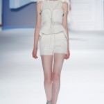 White super piqué peplum tailored vest with oversized hood over white textured silk sleeveless top & white super piqué skirted short