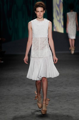 Look 9: White lace jacquard cropped sleeveless choli jacket over white guipure tank with side vents over white cotton eyelet parasol skirt | Photography: Dan Lecca